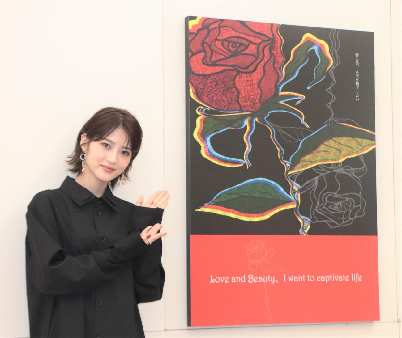 「第106回二科展」のデザイン部で特選賞に選ばれた自身の作品を指す若月佑美（撮影・藤塚大輔）