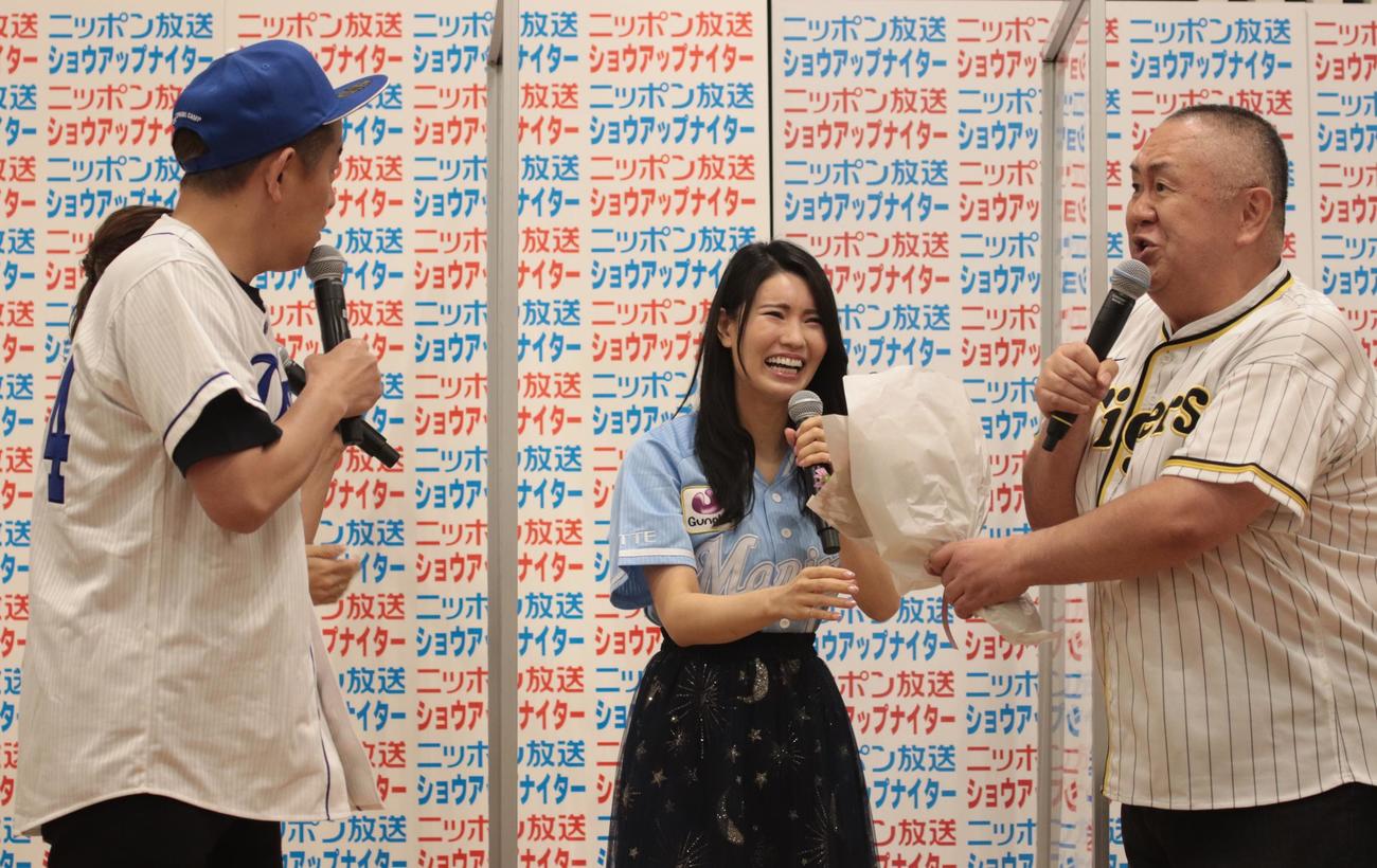 ニッポン放送のラジオ新番組「ラジオペナントレースNEXT」制作発表会見で倉持明日香（中央）に花束を贈呈する松村邦洋（右）。左は驚いた表情を浮かべるスピードワゴン井戸田潤（撮影・藤塚大輔）