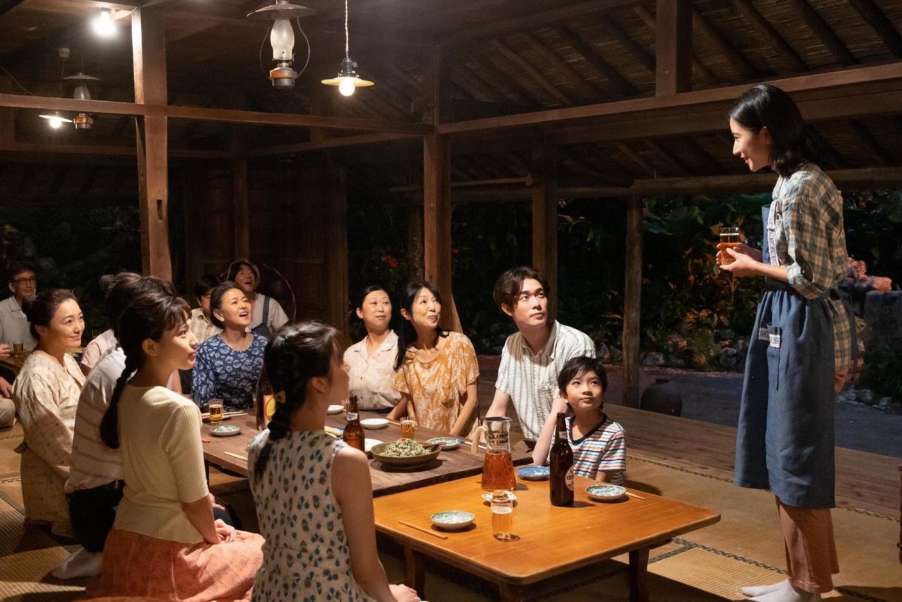 朝ドラ「ちむどんどん」より。故郷の沖縄やんばるの実家に集まった家族と仲間たちの前で話をする比嘉暢子（右端＝黒島結菜）(C)NHK
