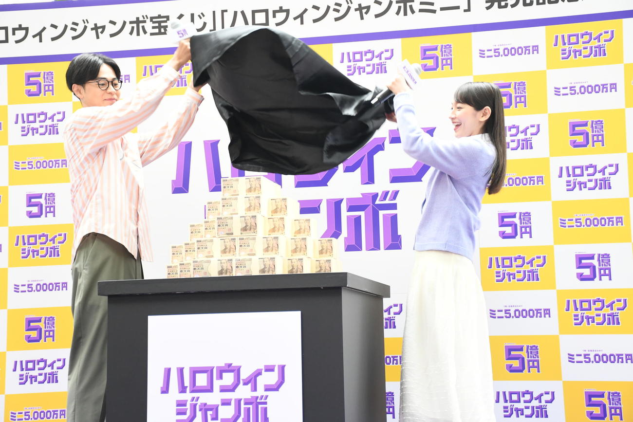 「ハロウィンジャンボ宝くじ」「ハロウィンジャンボミニ」発売記念イベントで5億円のレプリカのアンベールを行う成田凌（左）と吉岡里帆（撮影・大友陽平）