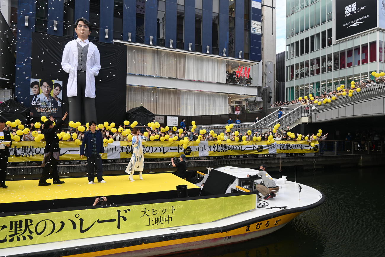 大阪・道頓堀に設置された「湯川先生像」をバックにしてフォトセッション後、ファンに手を振る左から北村一輝、福山雅治、柴咲コウ（撮影・松浦隆司）