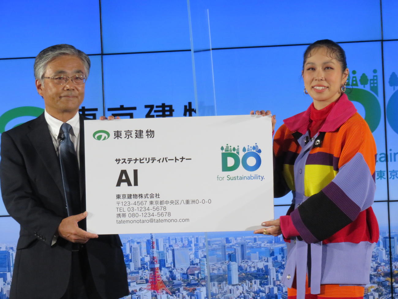東京建物野村均社長（左）からサステナビリティパートナーの名刺を受け取るAI