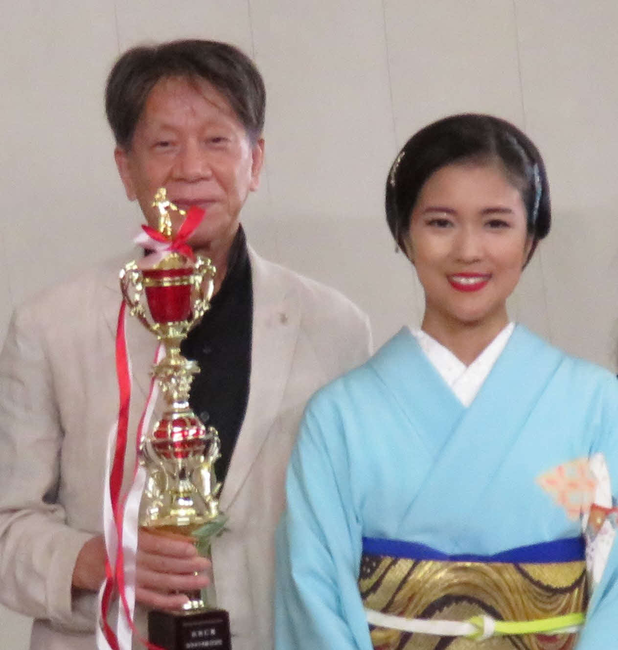 カラオケ大会で優勝した佐藤かつよしさんと出光仁美