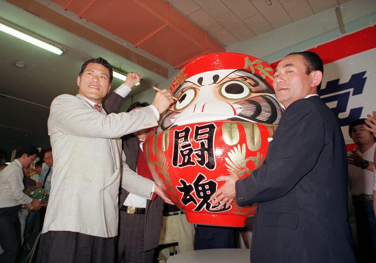 89年7月、参議院選挙に当選したスポーツ平和党のアントニオ猪木（左）は「闘魂」と書かれたダルマの目に墨を入れる