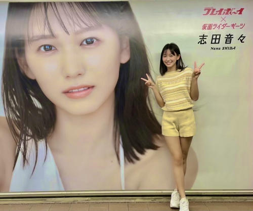 自身の巨大ポスターの前でポーズを取る志田音々