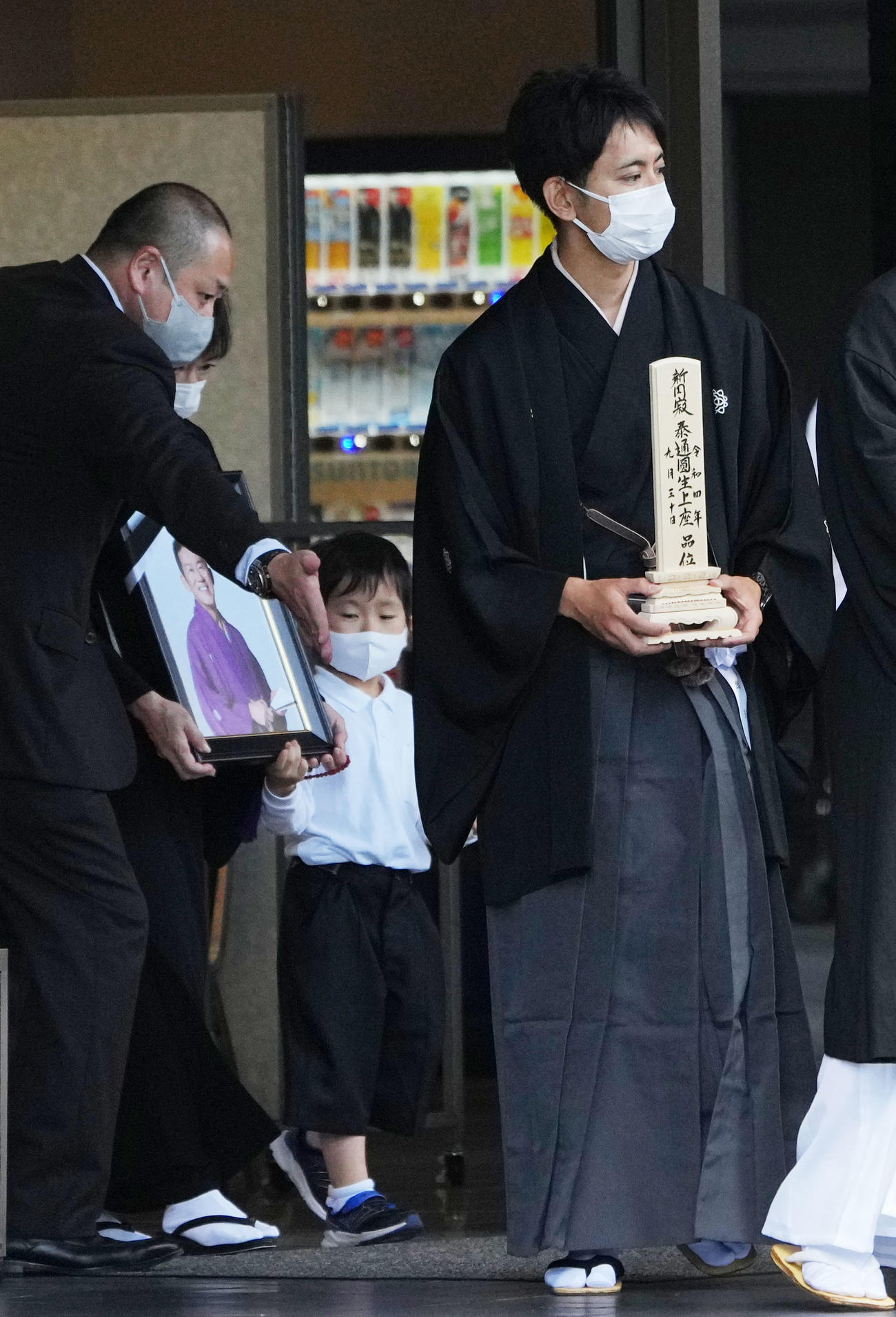三遊亭円楽さんの出棺の際に位牌（いはい）を持つ会一太郎（右）。後方は遺影を手にする妻（撮影・横山健太）