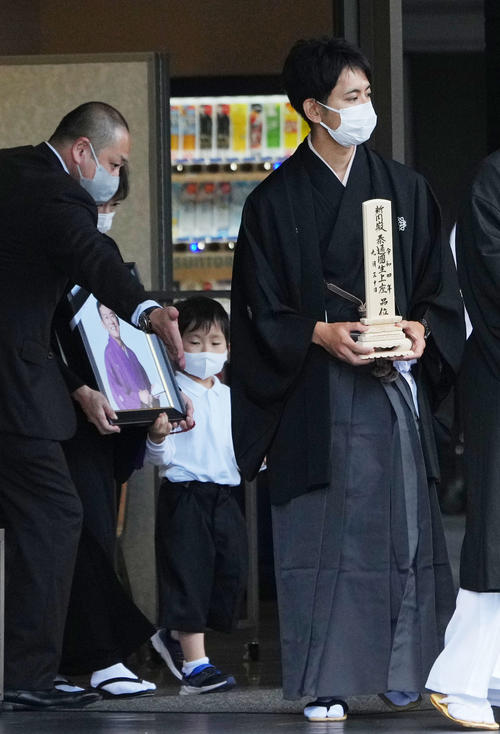 三遊亭円楽さんの出棺の際に位牌(いはい)を持つ会一太郎(右)。後方は遺影を手にする妻(撮影・横山健太)