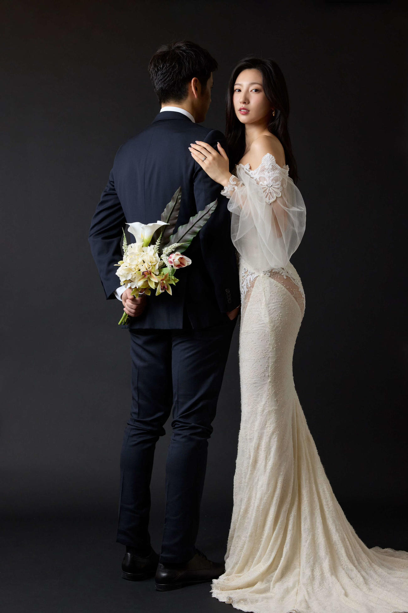 花束を手にしたバックショットの旦那様（左）との結婚を発表した福井セリナ