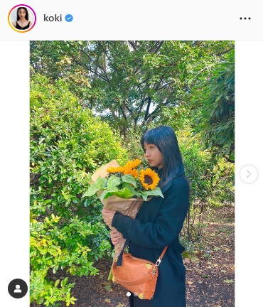 緑に囲まれた中でひまわりの花束を抱きしめるKoki，（Koki，のインスタグラムより）
