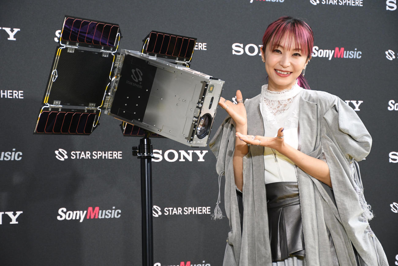 没入型の宇宙体験空間「PLAY SPACE．」オープニングステージで人工衛星とともに笑顔を見せるLiSA（撮影・大友陽平）