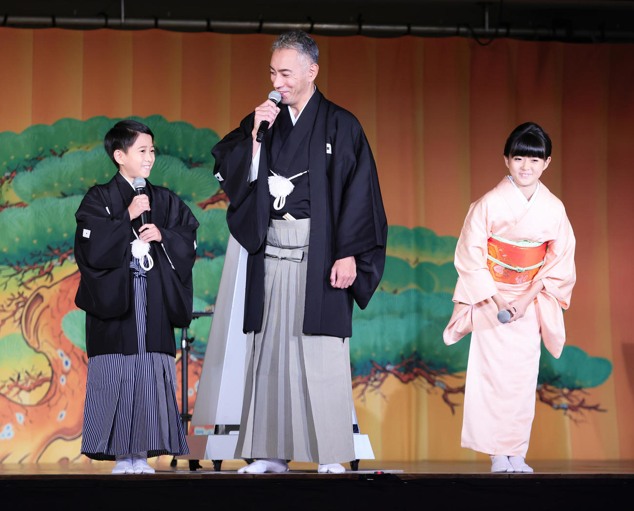 壇上で笑顔を見せる市川海老蔵（中央）と長男・堀越勸玄くん（左）、長女・市川ぼたん（撮影・足立雅史）
