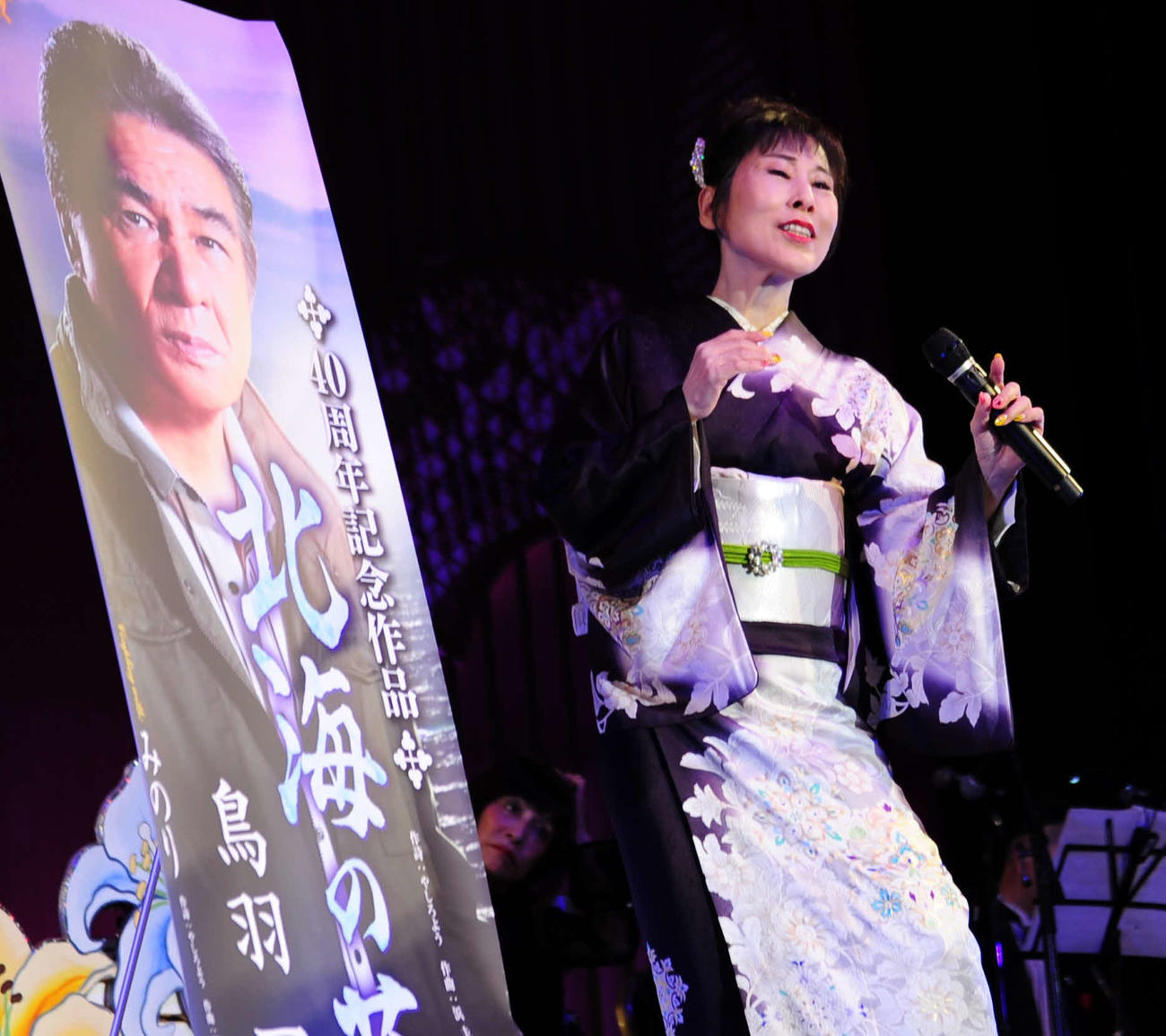 鳥羽一郎のパネルを隣に置いてデュエット曲「ふたり」を歌唱した原田悠里