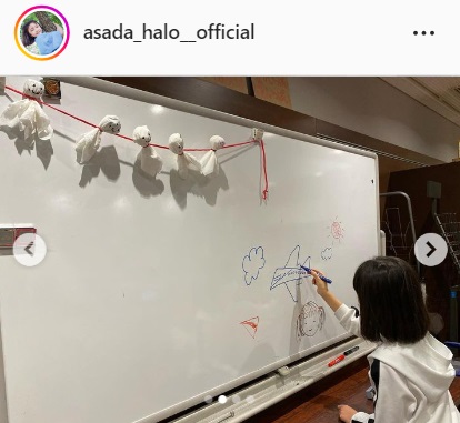 てるてるぼうずが飾られたホワイトボードにイラストを描く浅田芭路（浅田芭路のインスタグラムより）