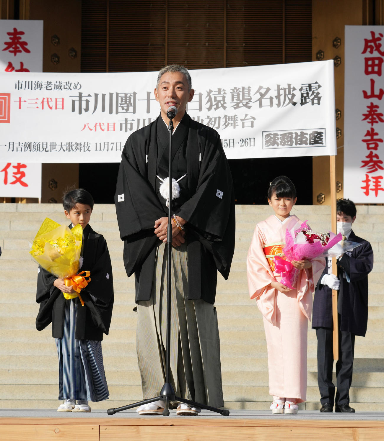 第13代目市川團十郎白猿襲名披露・八代目市川新之助初舞台「襲名奉告参拝」の歓迎式であいさつする市川海老蔵。左は長男の堀越勸玄くん、右は市川ぼたん（撮影・小沢裕）　