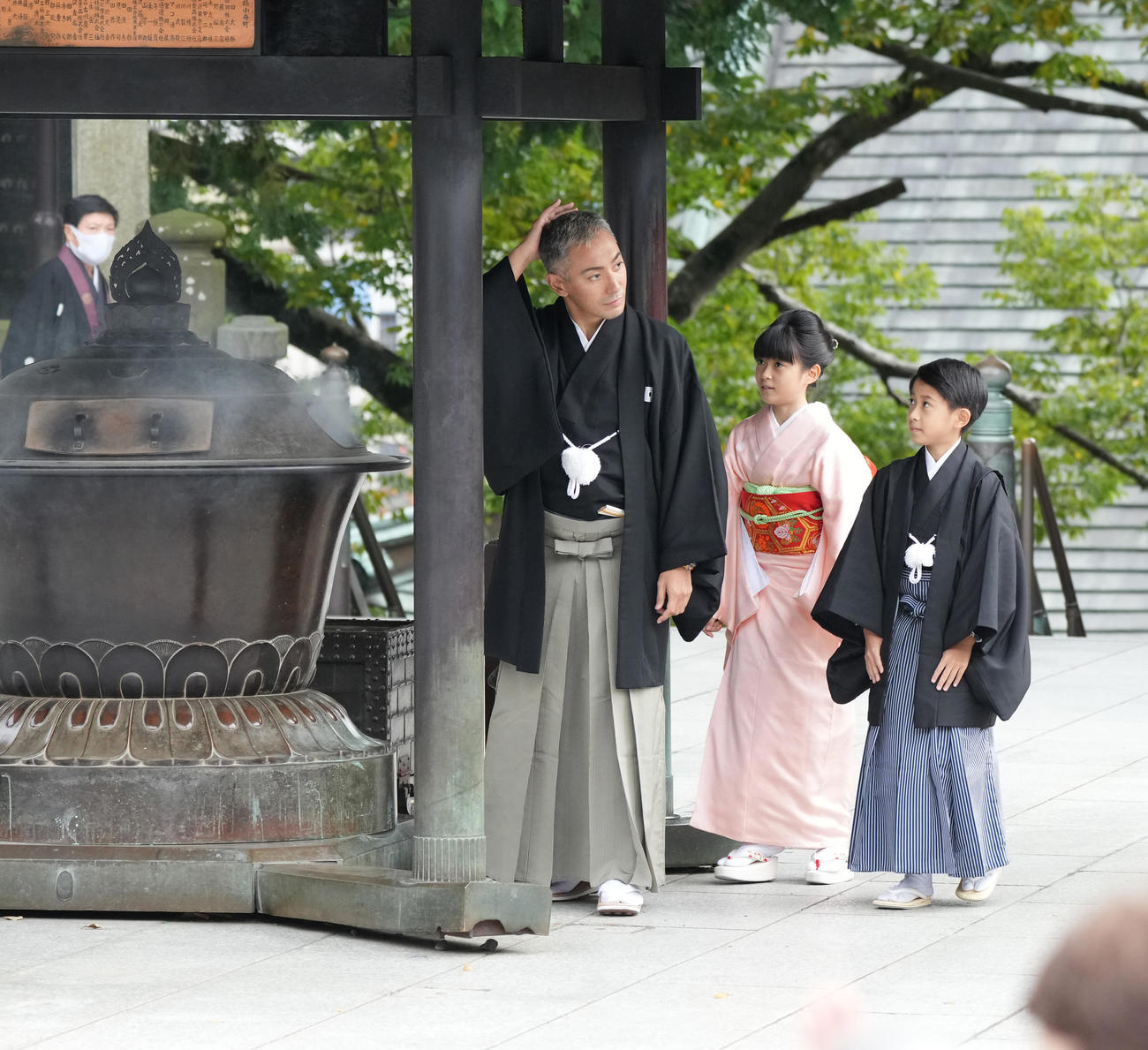 第13代目市川團十郎白猿襲名披露・八代目市川新之助初舞台「襲名奉告参拝」に臨んだ市川海老蔵（左）はお香の煙を手に取り頭に当てる。右へ長女の市川ぼたん、長男の堀越勸玄くん（撮影・小沢裕）　