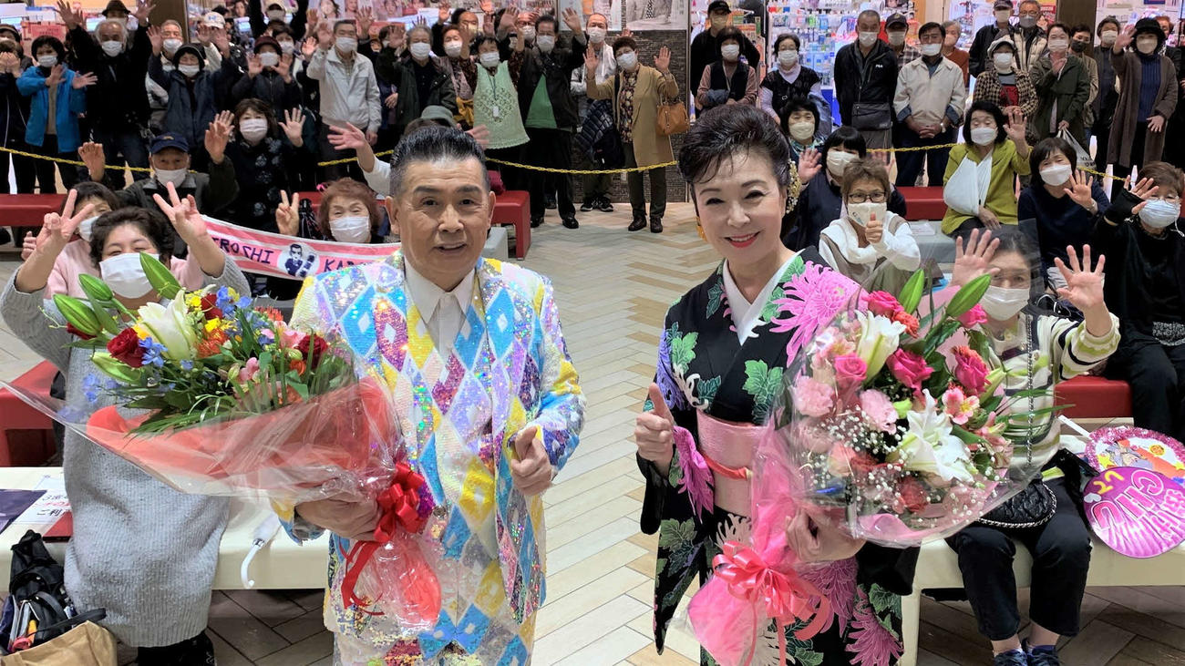 ファンからプレゼントされた花束を抱え記念撮影に応じる角川博（左）と岡ゆう子（右）