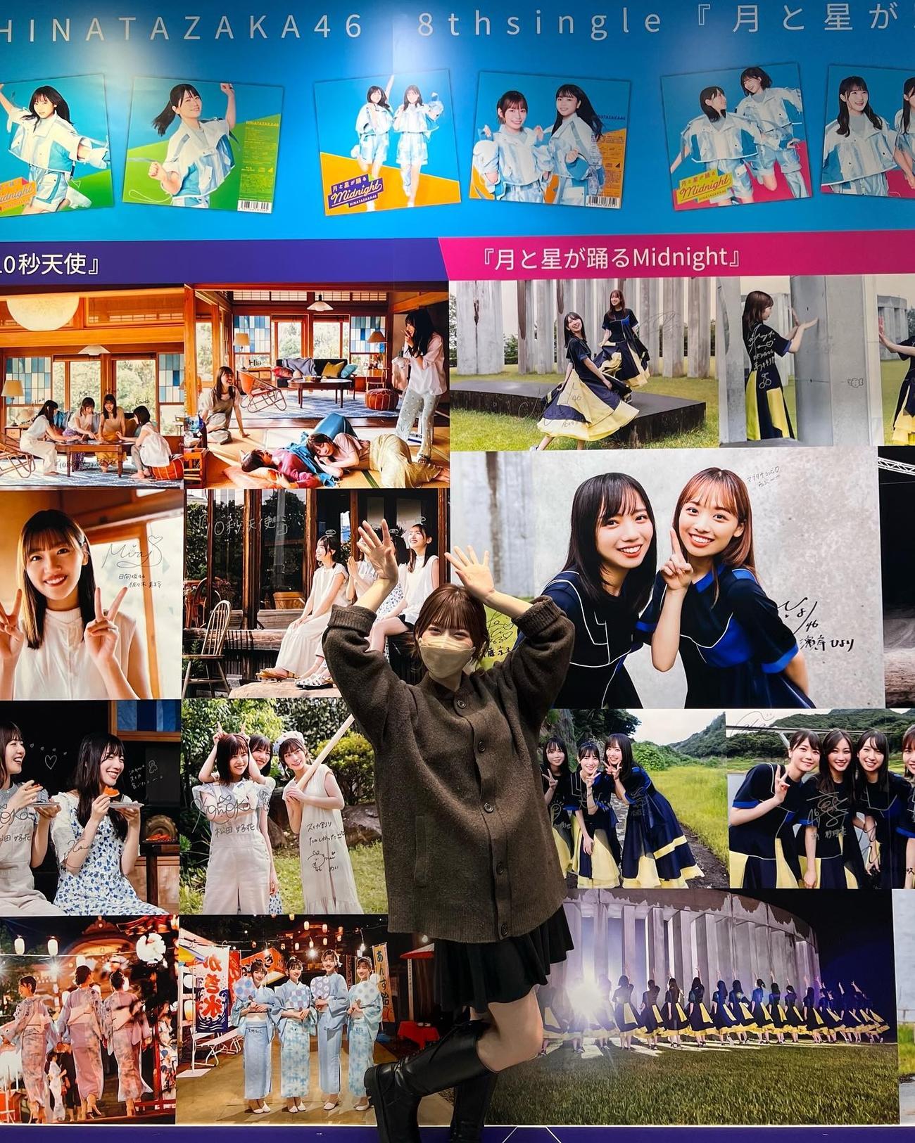 展示されたパネルを前に笑顔でポーズする日向坂46東村芽依。東村芽依インスタグラムより