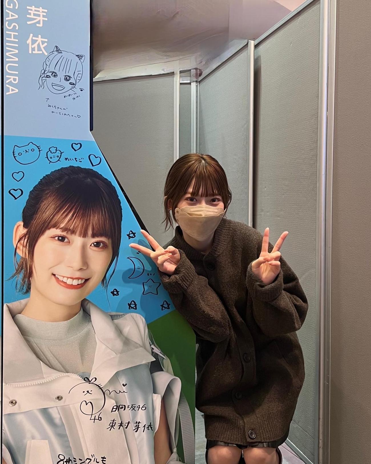 展示されたパネルを前にピースする日向坂46東村芽依。東村芽依インスタグラムより