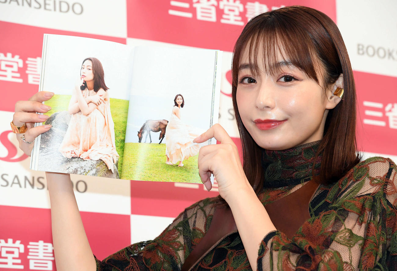 フォトエッセイ「風を食べる2」でお気に入りのページを見せる宇垣美里（撮影・たえ見朱実）