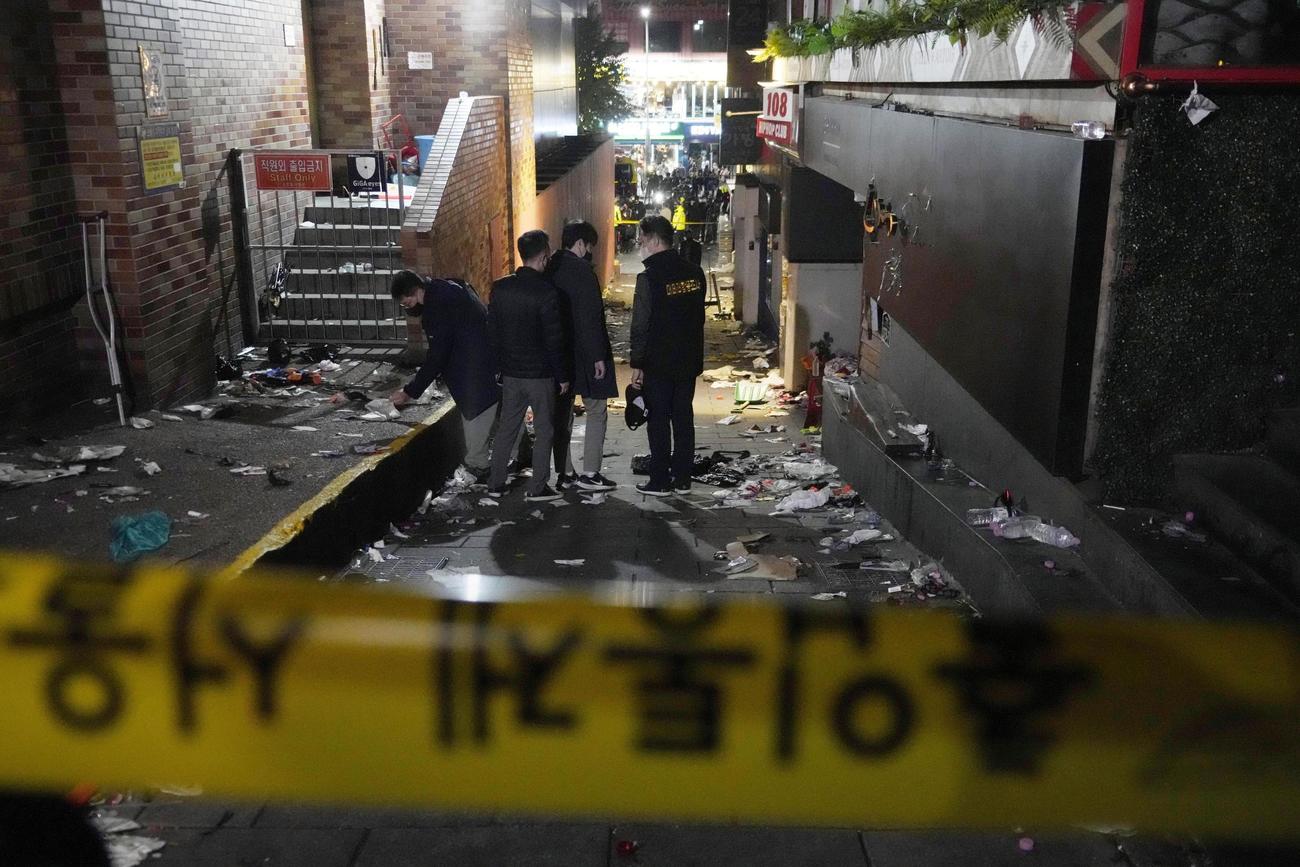 ソウルの繁華街・梨泰院で発生した事故で、現場の路地を調べる警察官＝30日（AP＝共同）