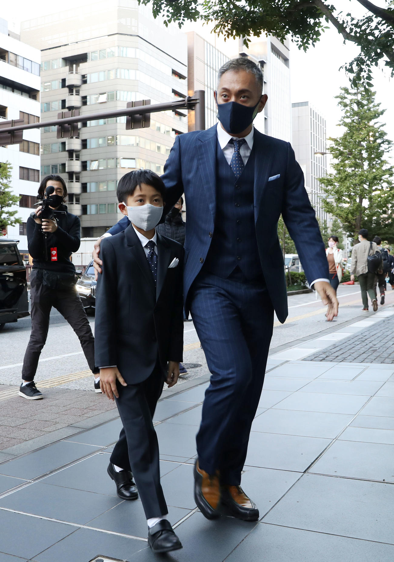 長男である8代目市川新之助（左）を抱き寄せ、自身の襲名披露記念公演が行われる歌舞伎座に入る13代目市川團十郎白猿（撮影・狩俣裕三）