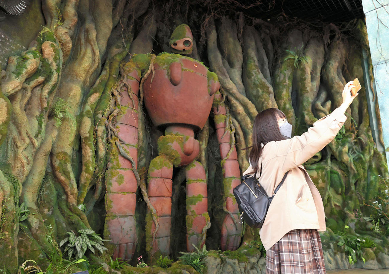 ジブリパーク「ジブリの大倉庫」エリアの「天空の庭」で写真を撮る来園者＝1日午前、愛知県長久手市（代表撮影）