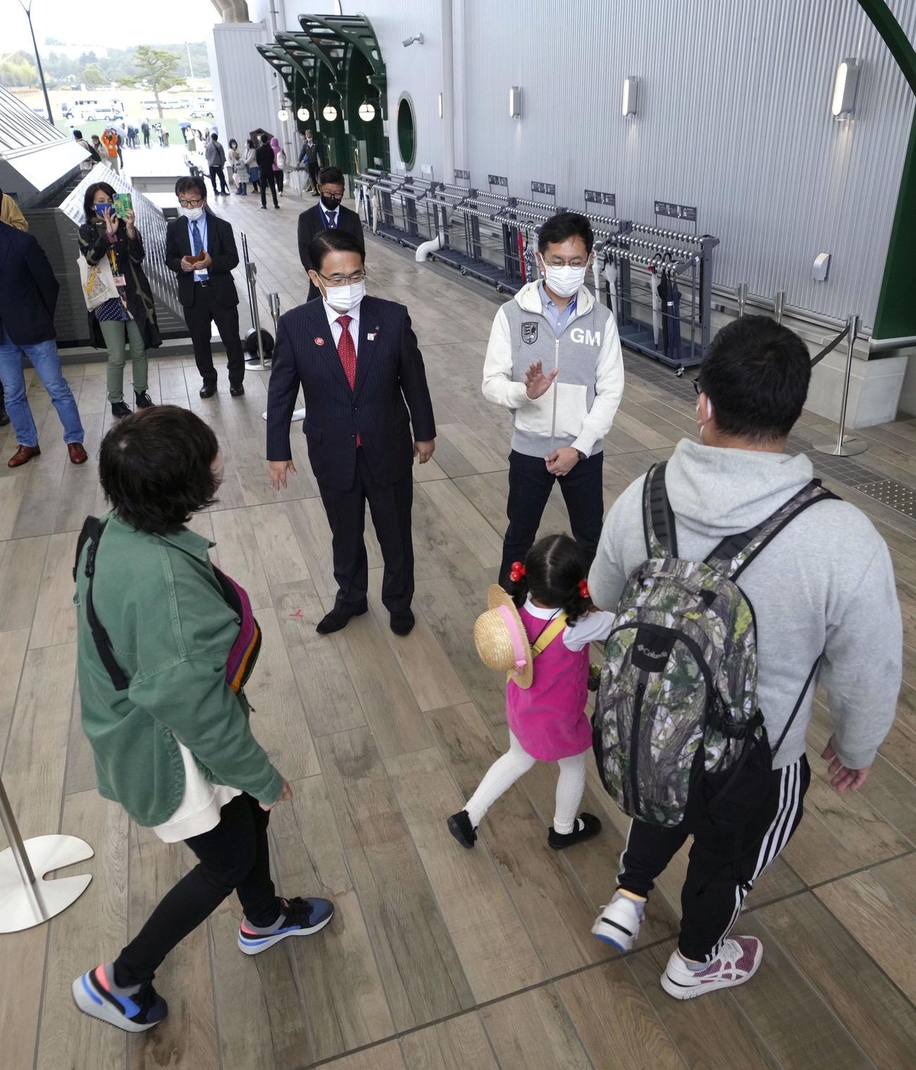 ジブリパークがオープンし、「ジブリの大倉庫」エリアで来場客を出迎える愛知県の大村秀章知事（奥左）と映画監督の宮崎吾朗氏（同右）＝1日午前、愛知県長久手市（共同）