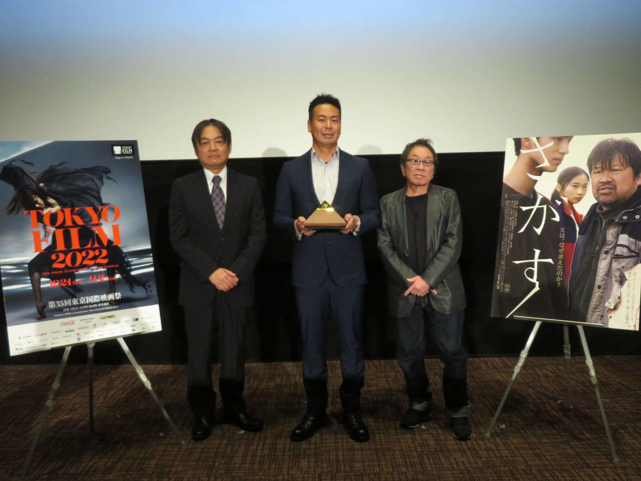日本映画監督協会新人賞を受賞し、本木克英理事長（左）からトロフィーを授与された片山慎三監督（中央）と選考委員の高橋伴明監督（撮影・村上幸将）