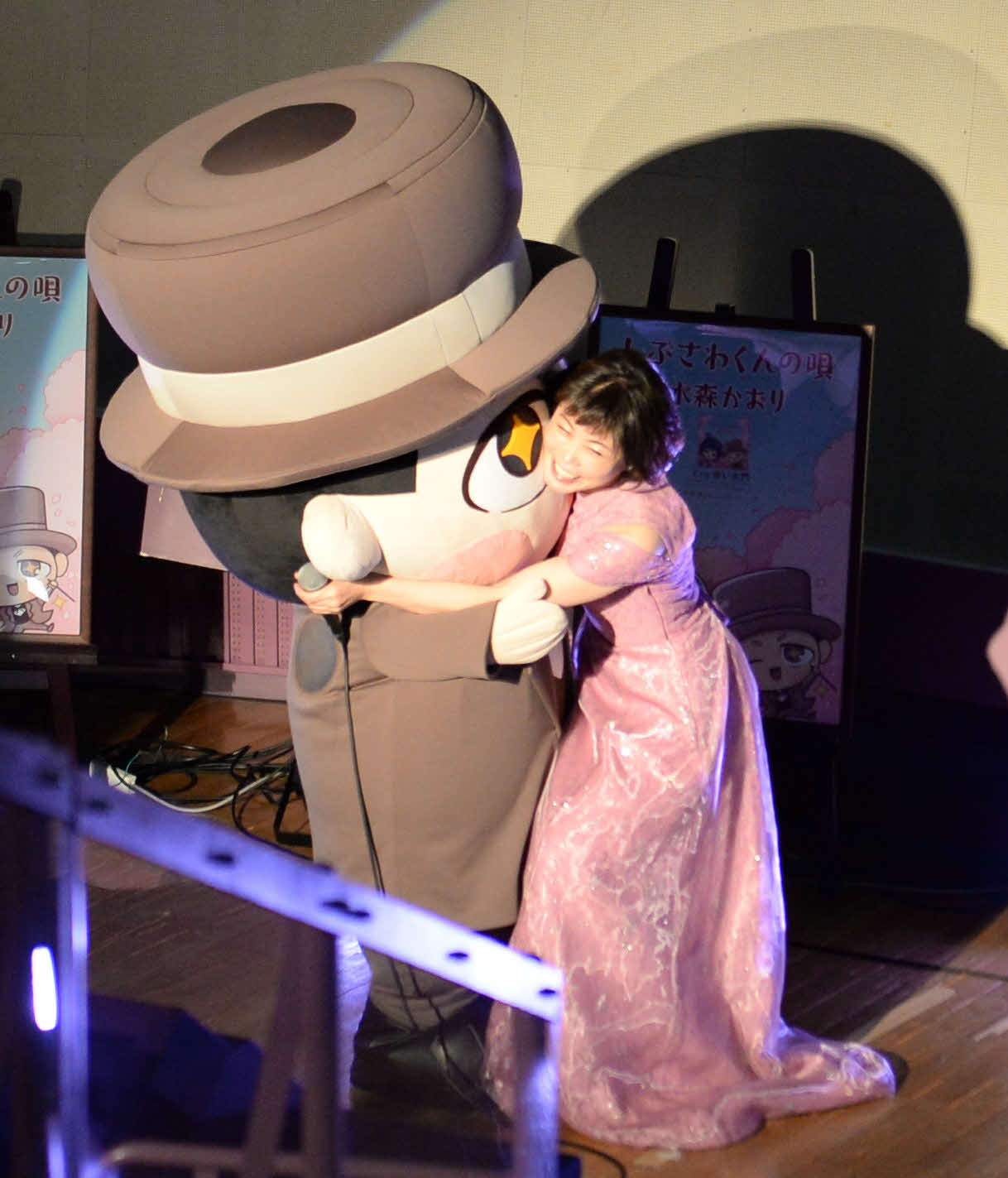 「しぶさわくんの唄」の発売記念イベントで、しぶさわくんに抱きつく水森かおり