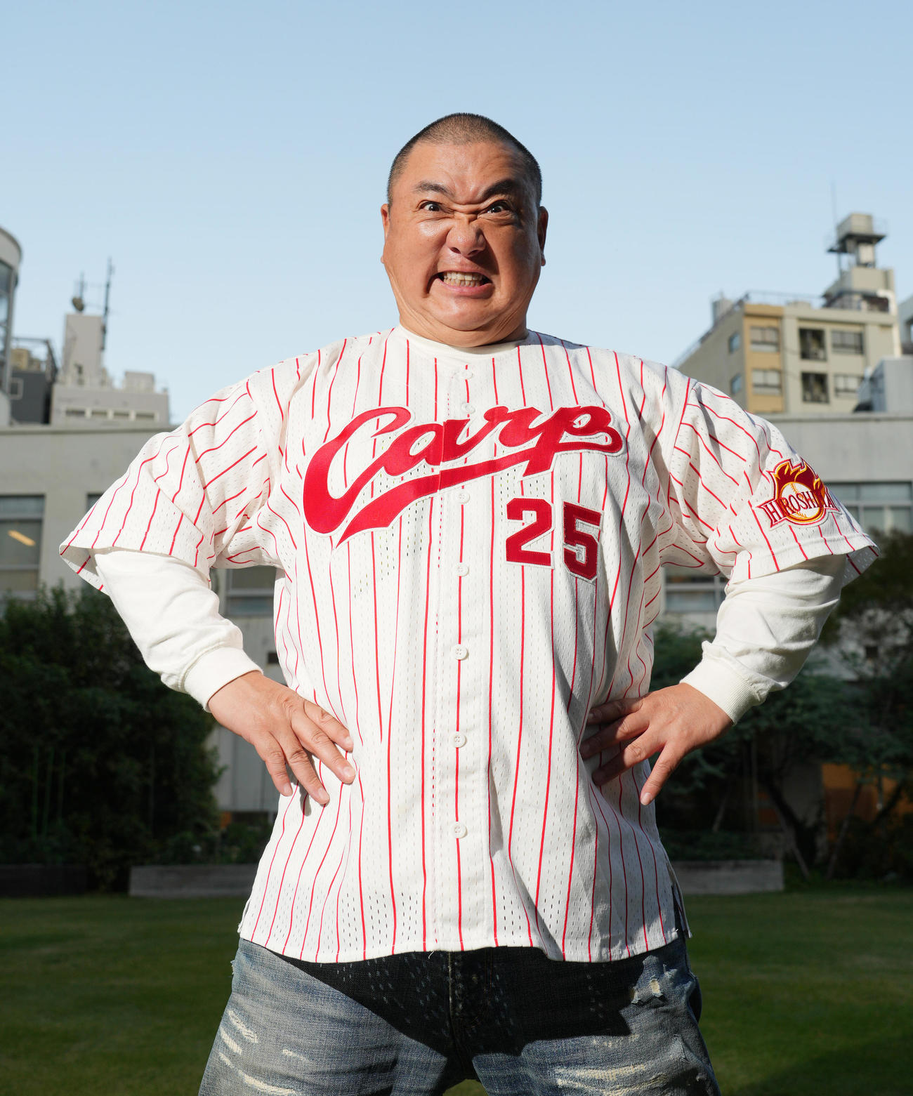 広島新井貴浩監督のユニホームを着て元気いっぱいポーズをとる極楽とんぼの山本圭壱（撮影・菅敏）