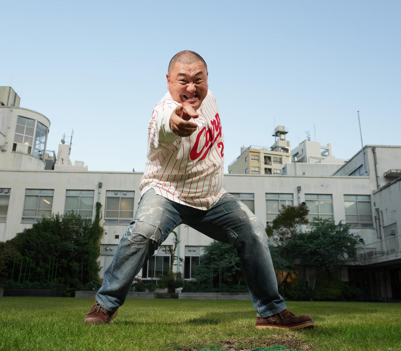 広島新井貴浩監督のユニホームを着て元気いっぱいポーズをとる極楽とんぼの山本圭壱（撮影・菅敏）