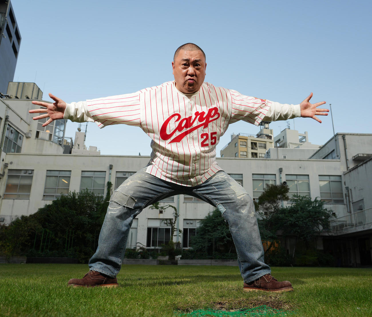 広島新井貴浩監督のユニホームを着て元気いっぱいポーズをとる極楽とんぼの山本圭壱（撮影・菅敏）