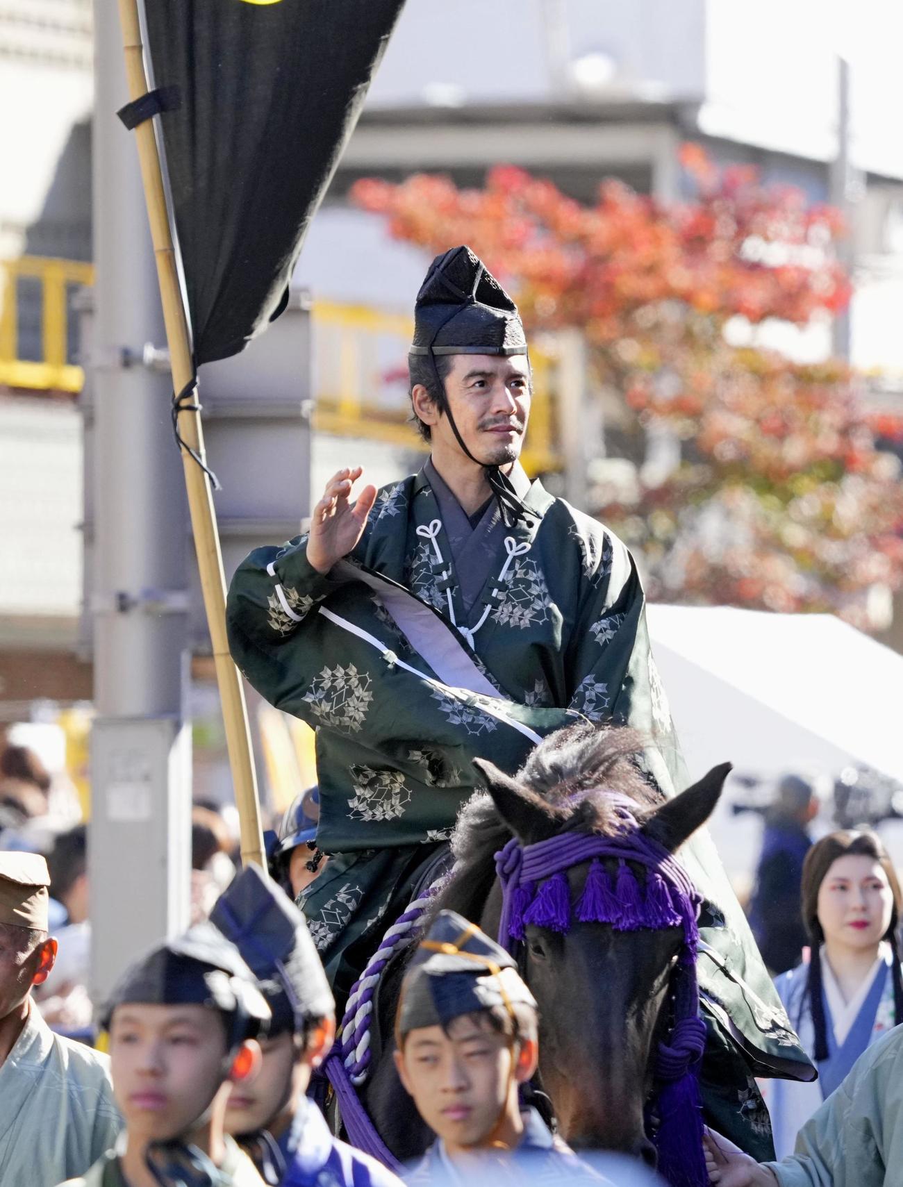 「信長公騎馬武者行列」で沿道の観客に手を振る伊藤英明さん＝6日午後、岐阜市（共同）