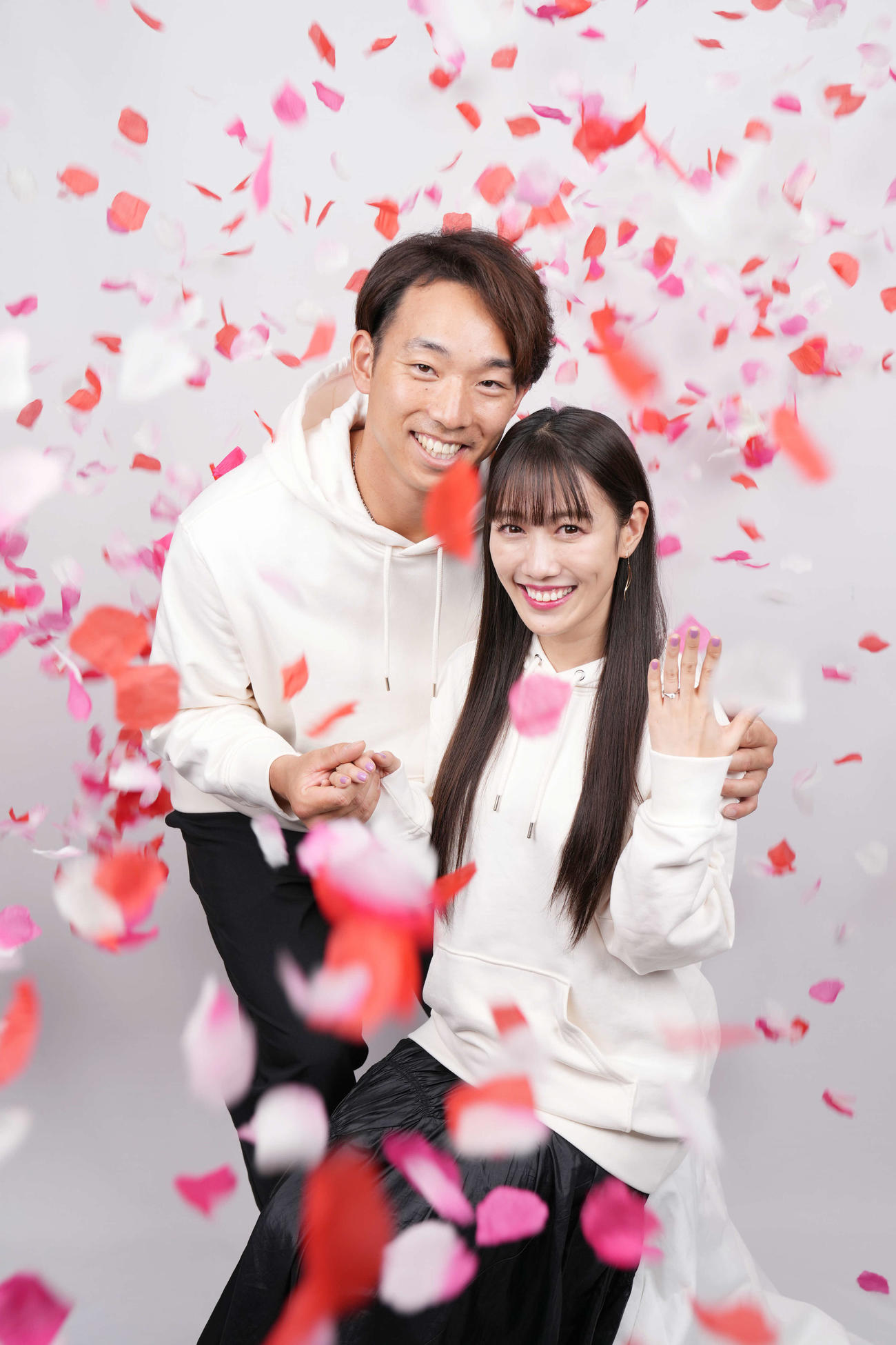 東京本社を訪れ、結婚の報告をした日本ハム宇佐見（左）と、花びらが舞う中で指輪を披露するももいろクローバーZの高城れに（撮影・菅敏）