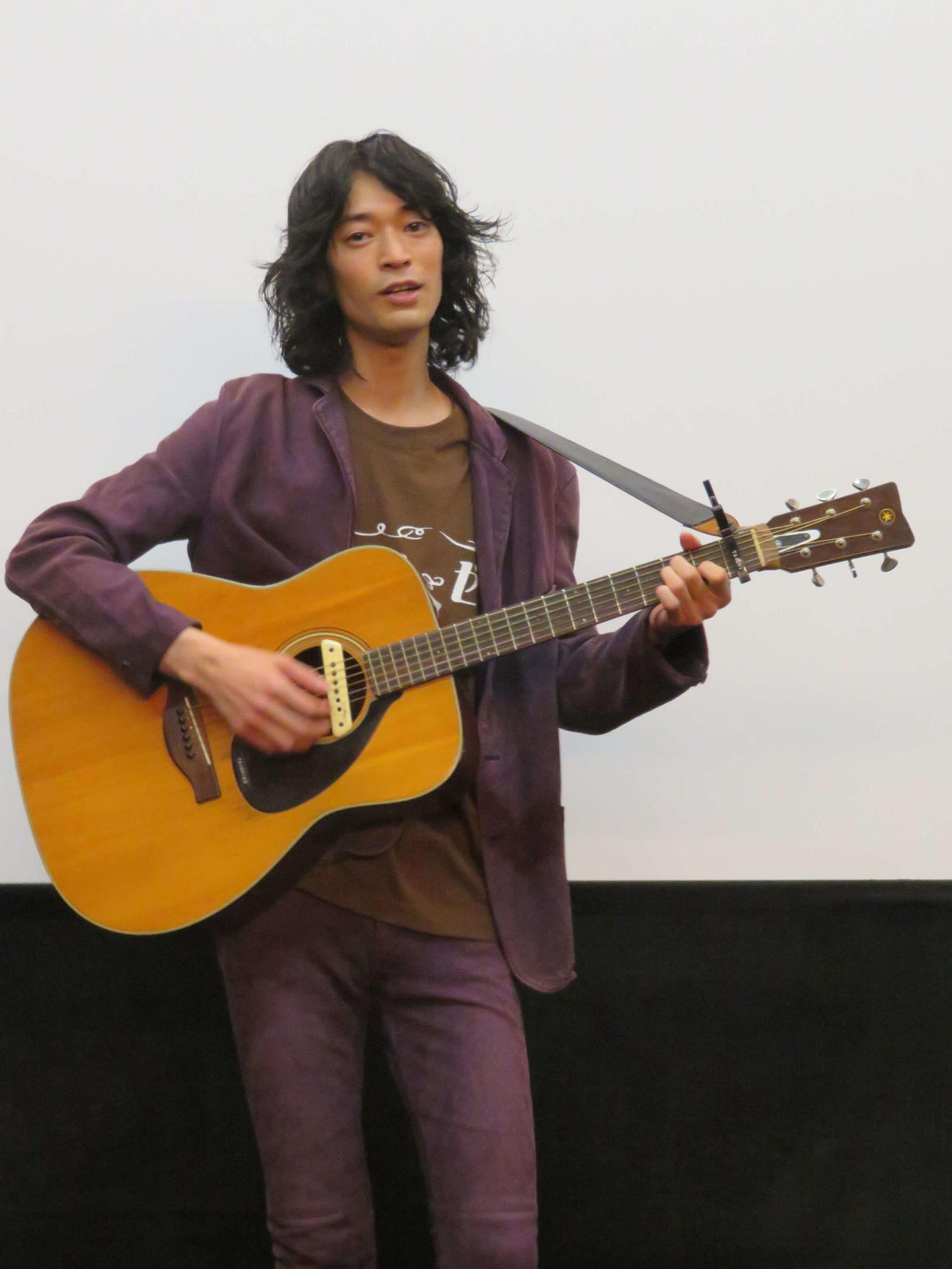 映画「ゆめのまにまに」初日舞台あいさつで主題歌「サンローゼ」を弾き語りで歌う、こだまたいち（撮影・村上幸将）