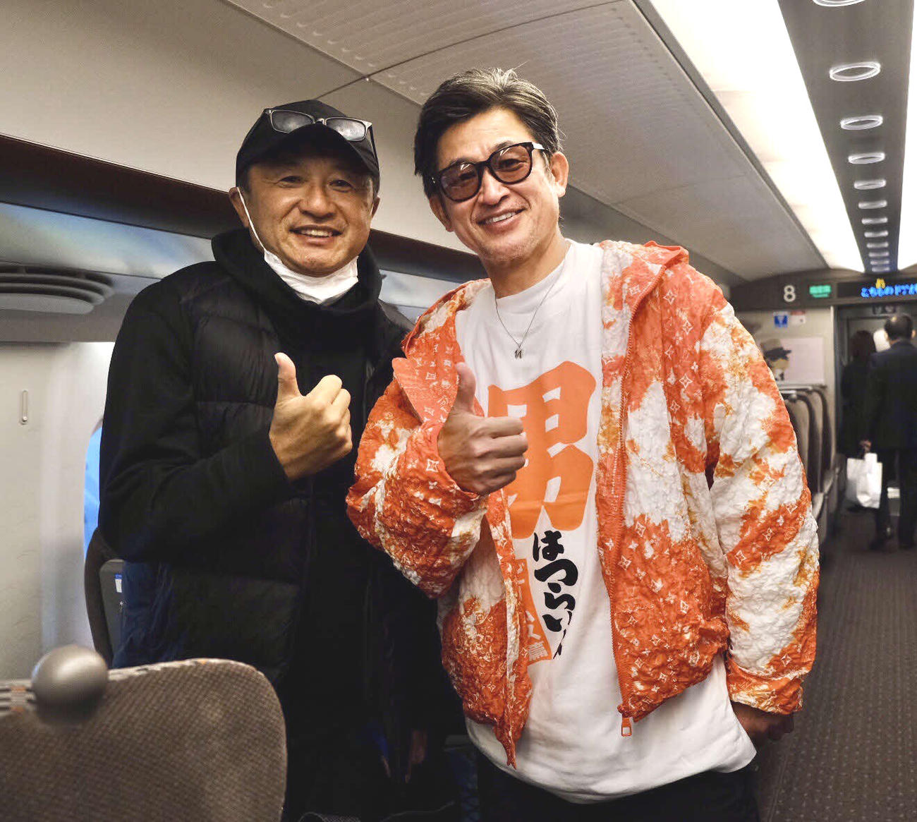 北九州から帰京する途中の新幹線の車内で偶然、一緒になった鈴鹿FWカズ（右）と記念撮影した武田修宏氏