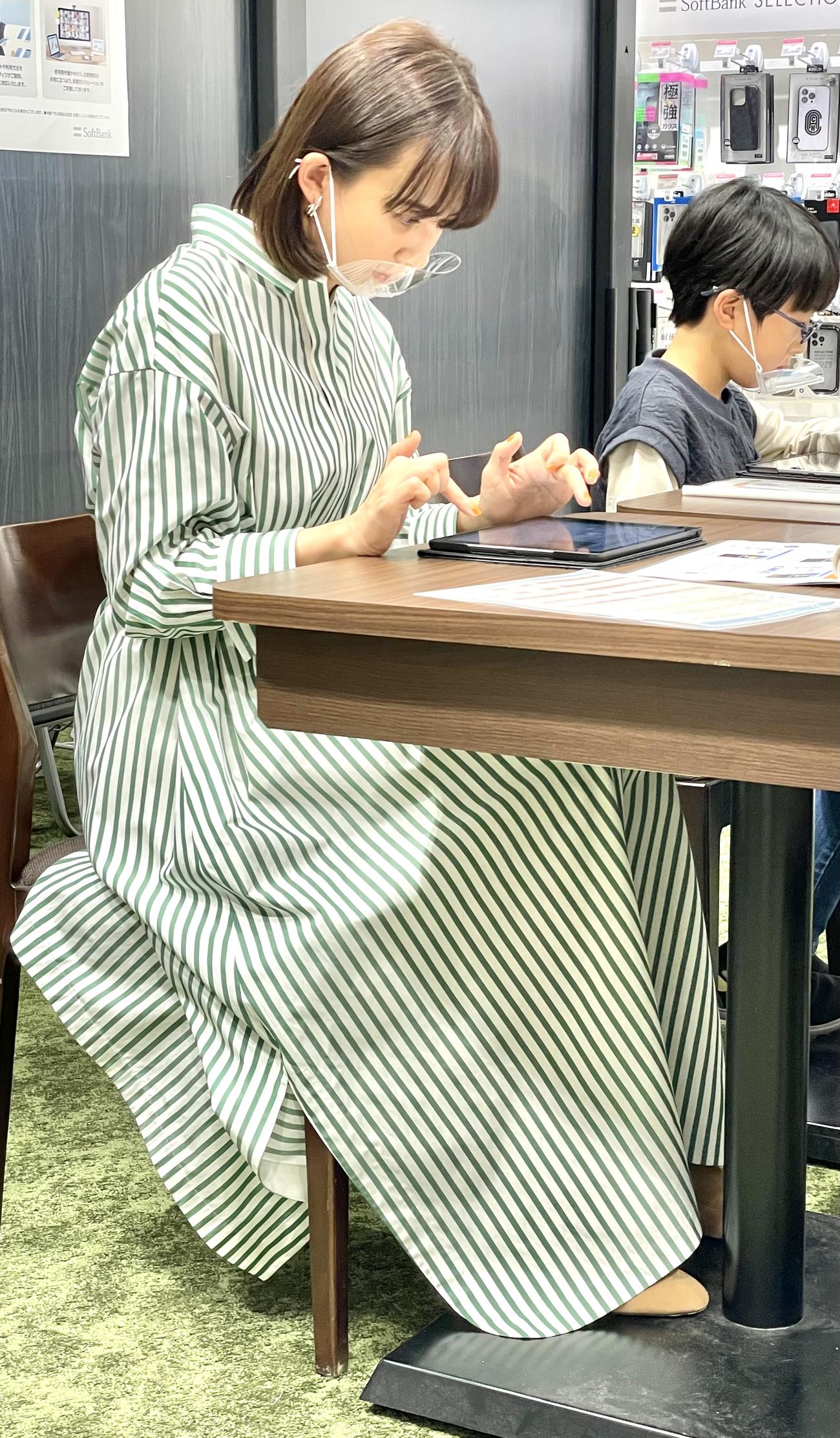 小学生に交じって両手を駆使してプログラミングに挑戦する優木まおみ
