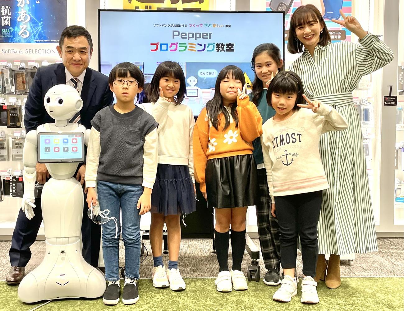Pepper、子どもたち5人と記念写真を撮る優木まおみ(右端)。左端はソフトバンクロボティクスの蓮実一隆CMO（最高マーケティング責任者）
