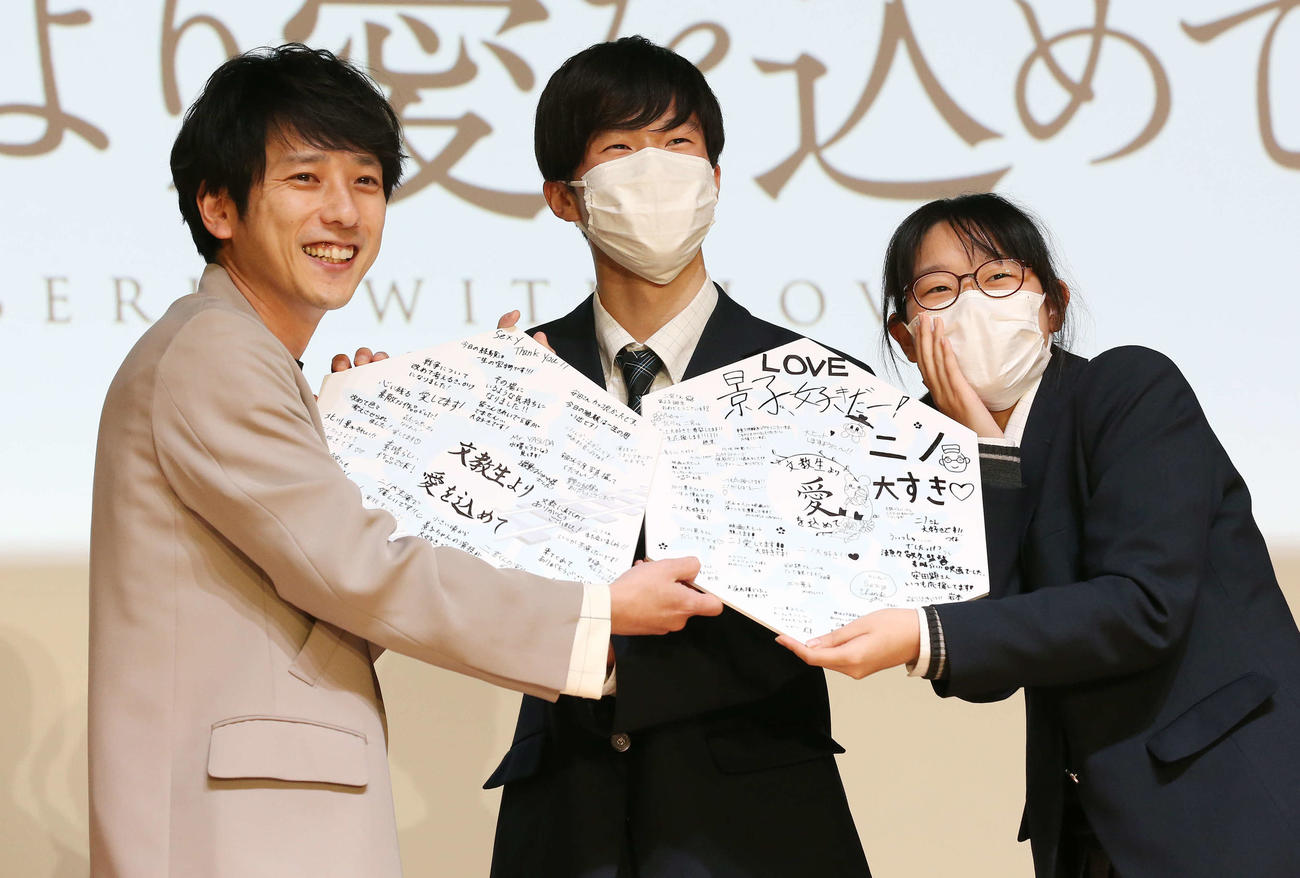 映画「ラーゲリより愛を込めて」高校生試写会で寄せ書きを手に生徒と記念写真を撮る二宮和也（左）（撮影・宮地輝）