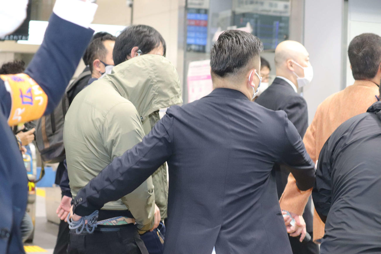 取り囲まれながら東京駅を後にする田中聖容疑者（左）