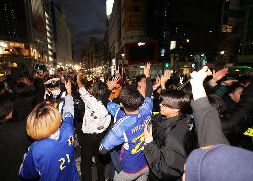 日本代表が決勝T進出を決め、渋谷スクランブル交差点でハイタッチを交わしながら横断するサポーター（撮影・河田真司）