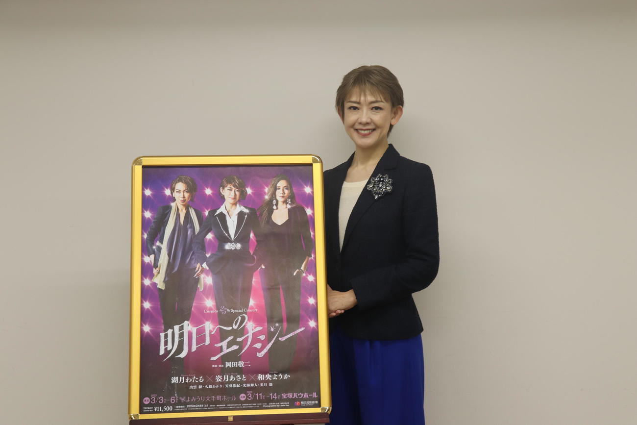 ポスターの横に立ち、笑う姿月あさと（撮影・竹本穂乃加）＝2022年12月8日、大阪・梅田芸術劇場