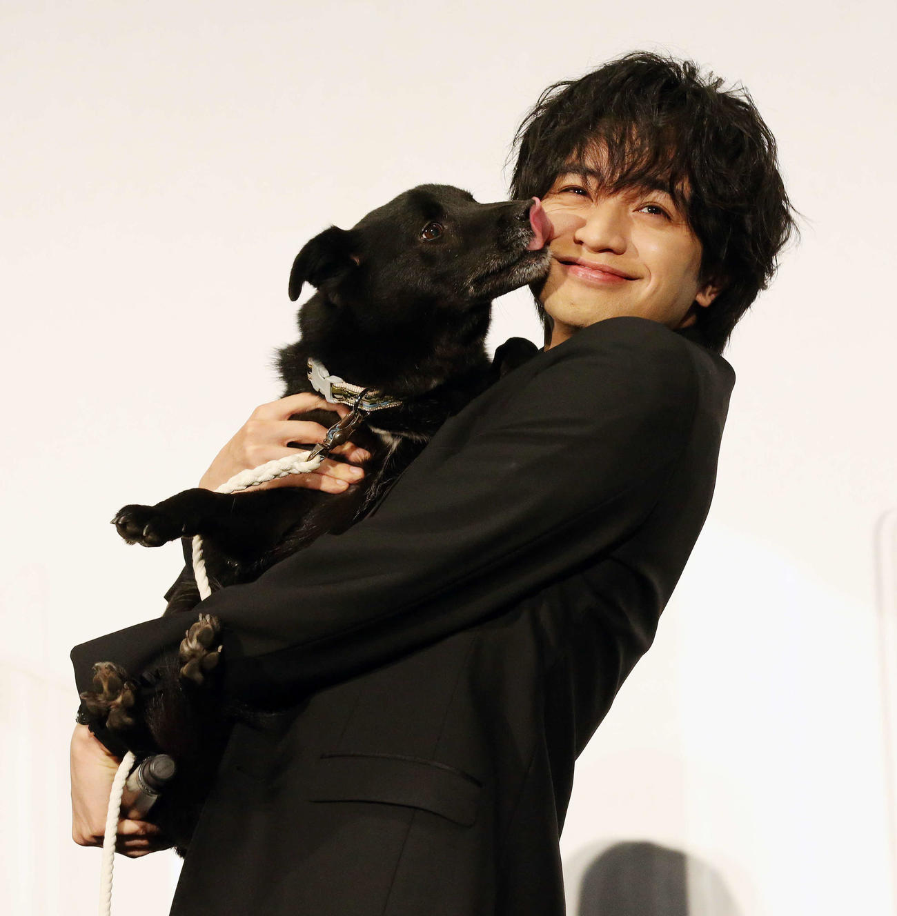 映画「ラーゲリより愛を込めて」初日舞台あいさつで犬の大吉にキスされて笑顔を見せる中島健人（撮影・宮地輝）