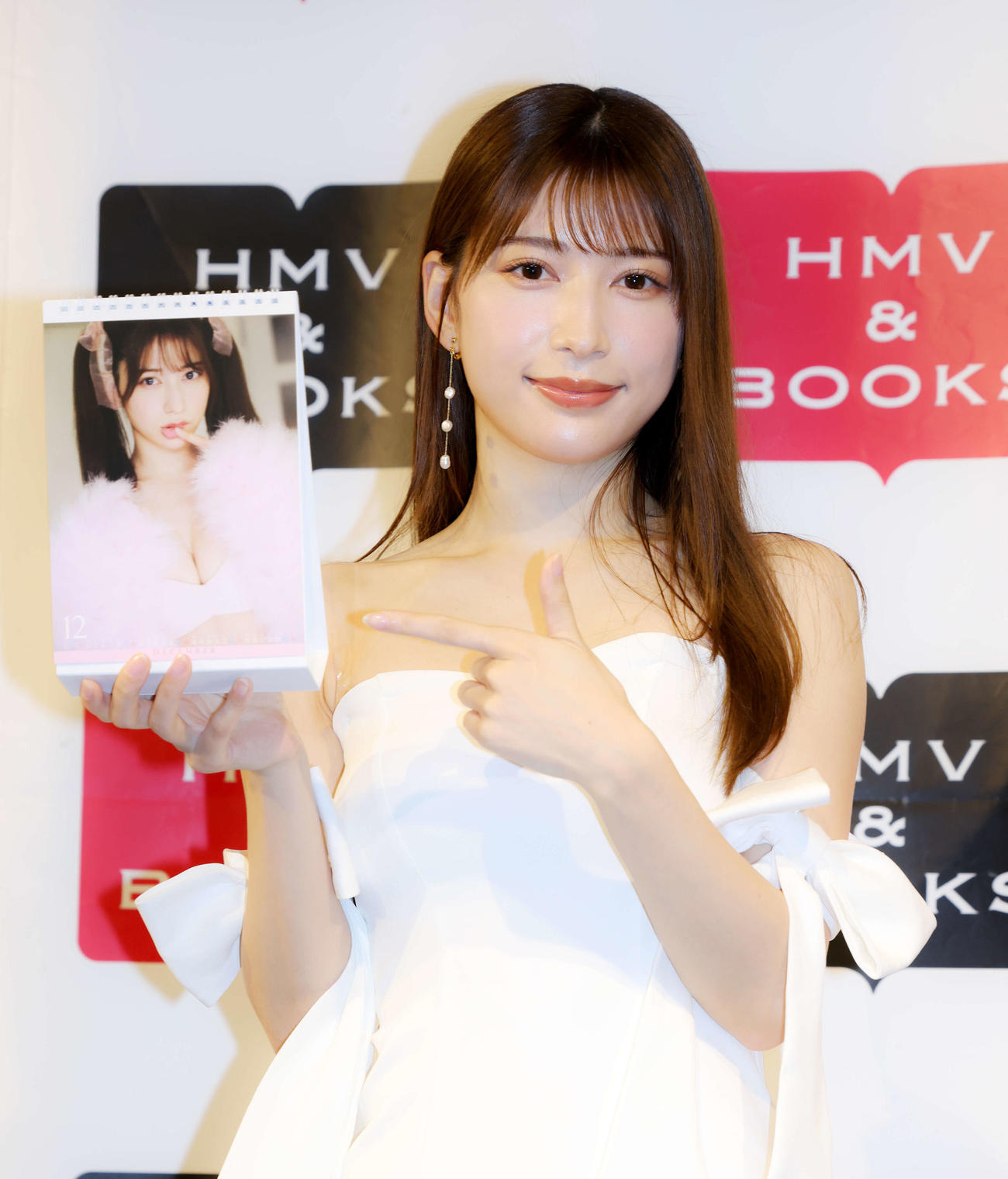 2023カレンダーのお気に入りカットを指さし写真に納まる雪平莉左（撮影・河田真司）