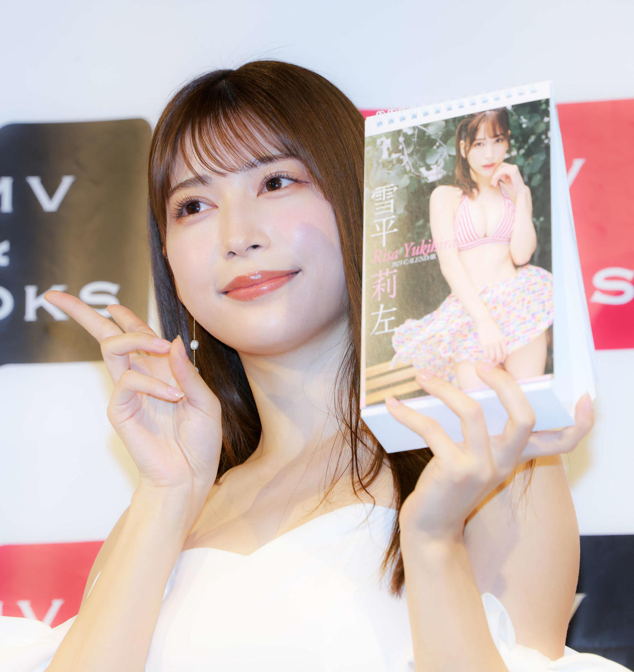 2023年卓上カレンダーを手にピースで写真に納まる雪平莉左（撮影・河田真司）