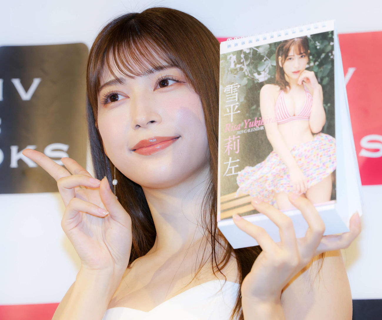 2023年卓上カレンダーを手にピースで写真に納まる雪平莉左（撮影・河田真司）