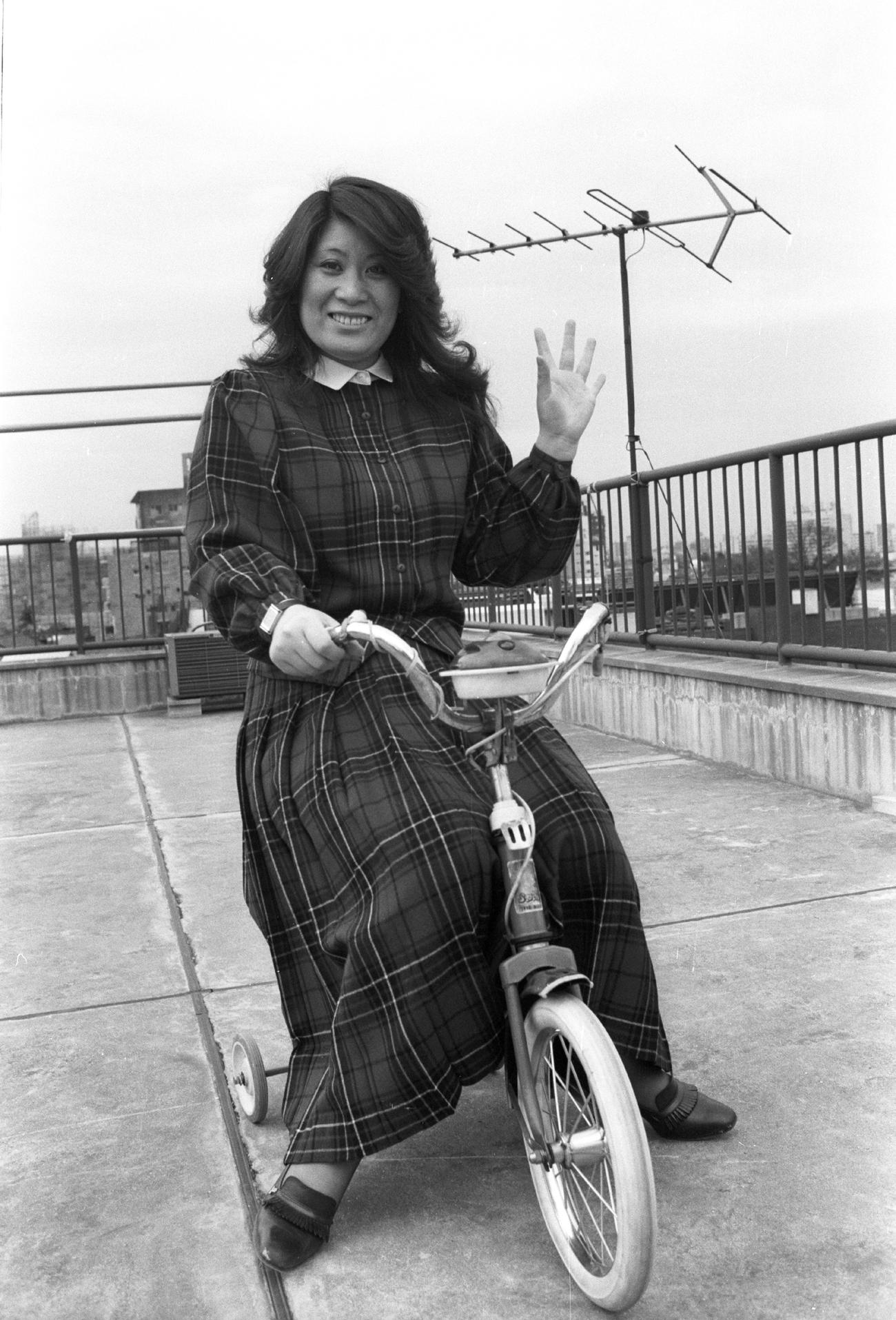 79年3月、補助輪付き自転車にまたがり笑顔で手を振る、あき竹城さん