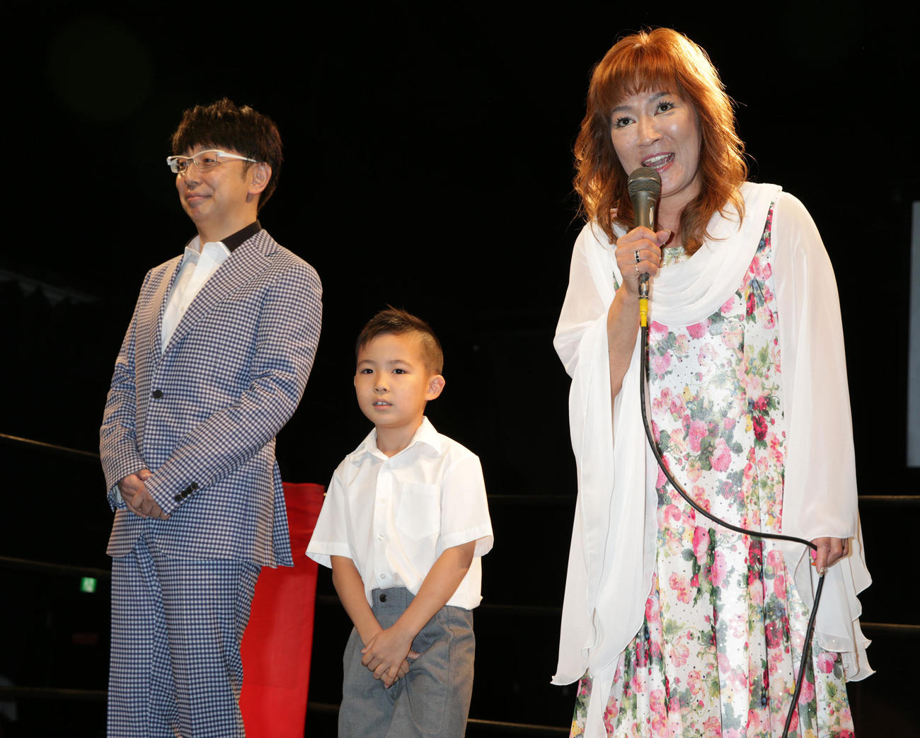 2014年7月、結婚10周年記念パーティーであいさつするジャガー横田。左から夫の木下博勝さん、長男大維志くん