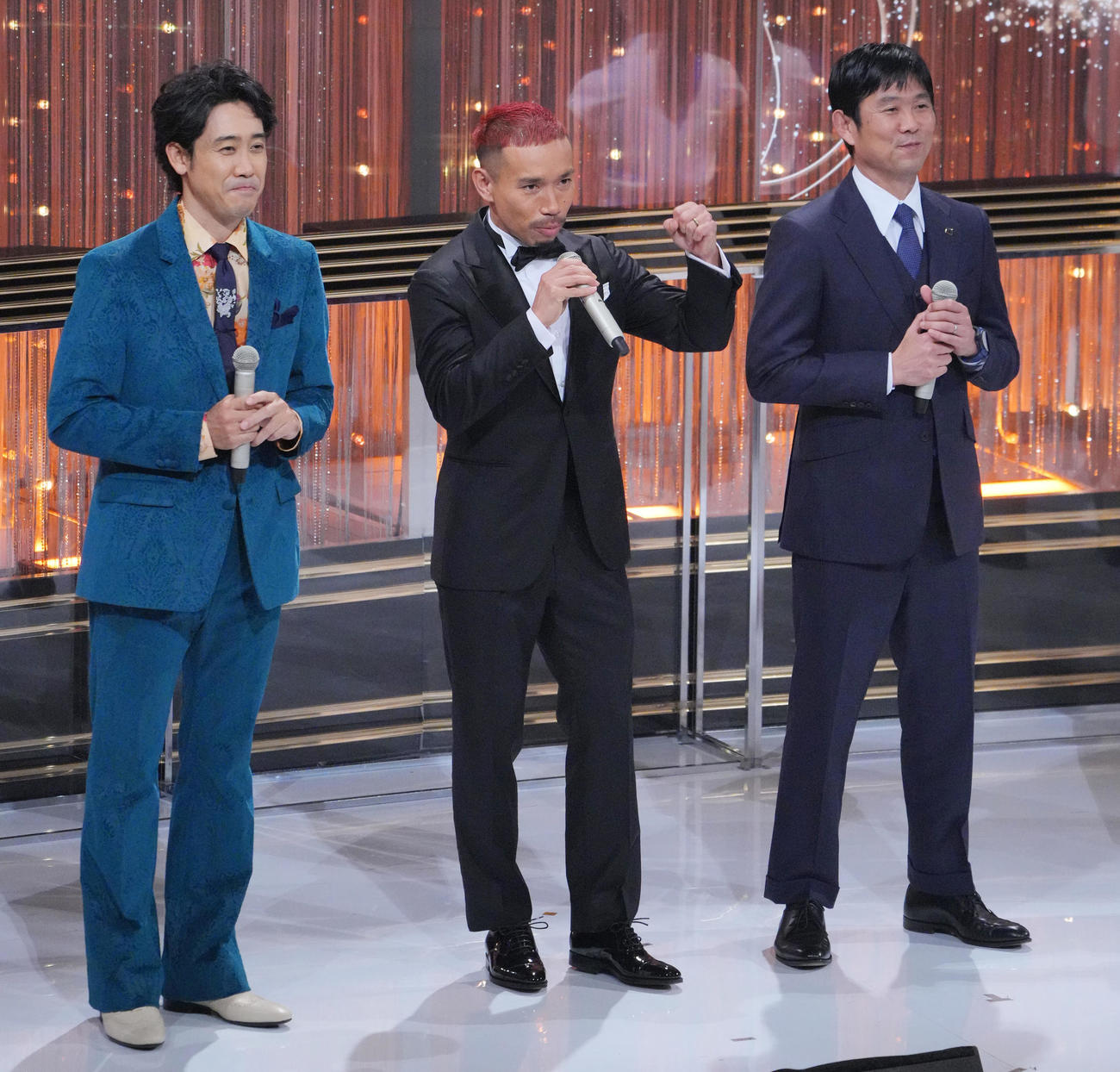 ガッツポーズを見せる長友（中央）。左は大泉洋、右は森保監督（撮影・垰建太）