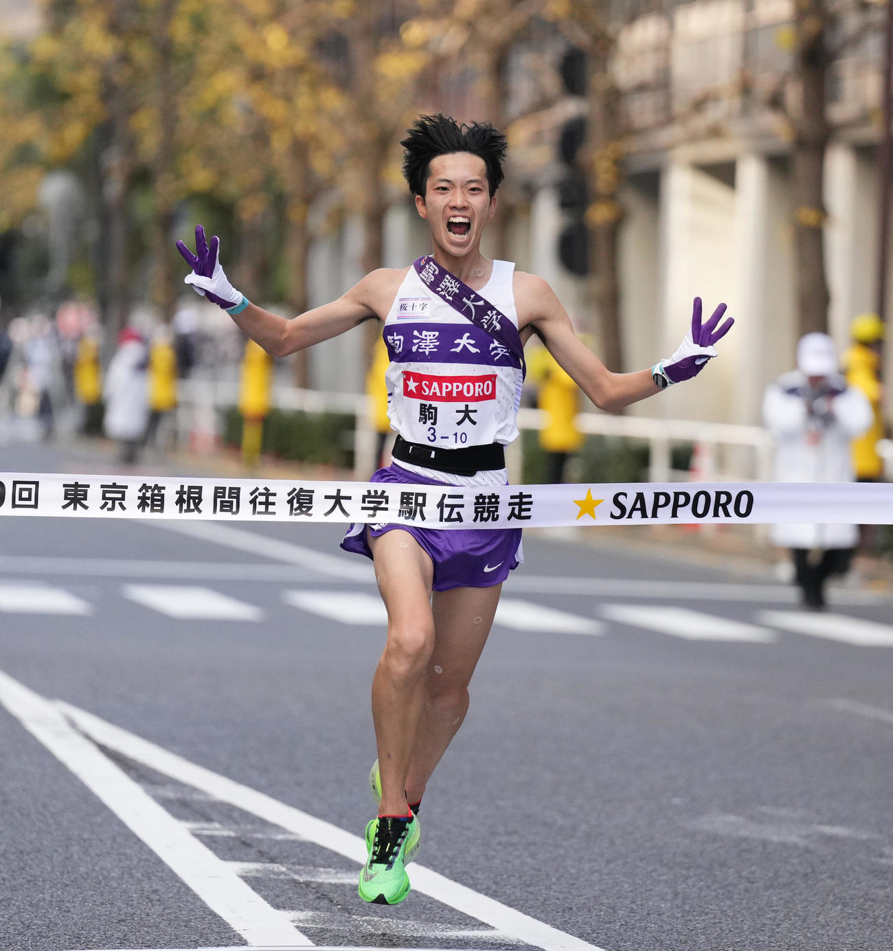 総合優勝を果たし、指で3と作りゴールする駒大10区青柿（撮影・菅敏）